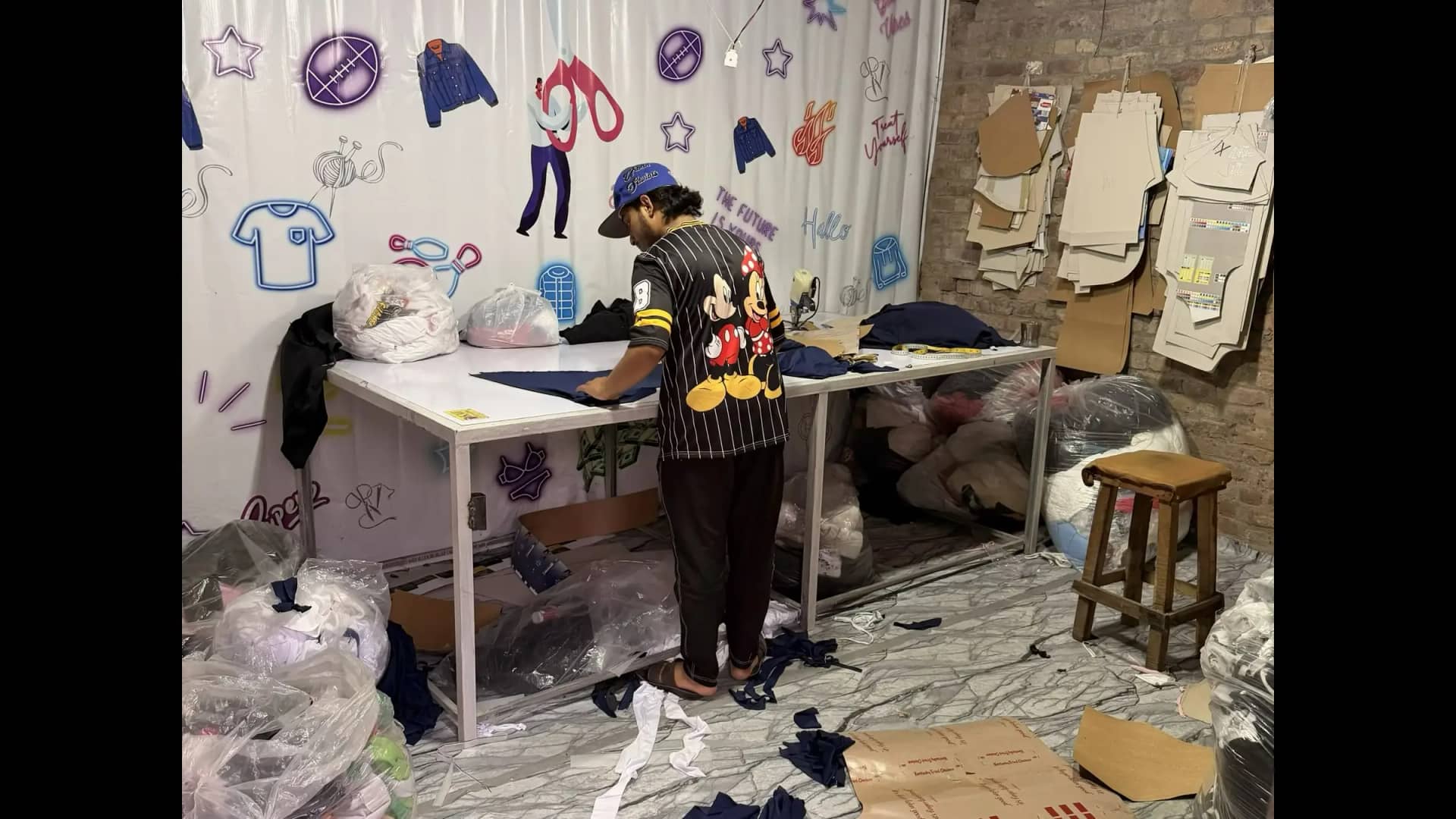 Tailor laying out cut pieces ready for sewing — Mughal Apparel factory Daska